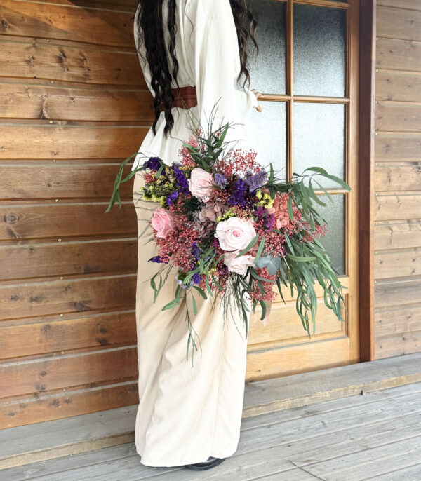 Payenne, l'artisane des fleurs éternelles, tenant un bouquet fait main dans son atelier de la forêt des Landes