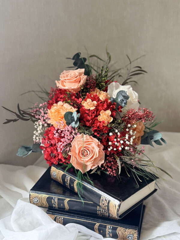 Bouquet de fleurs éternelles Siena avec des teintes corail, pêche, rouge, blanc et rose, dans un style bohème chic.