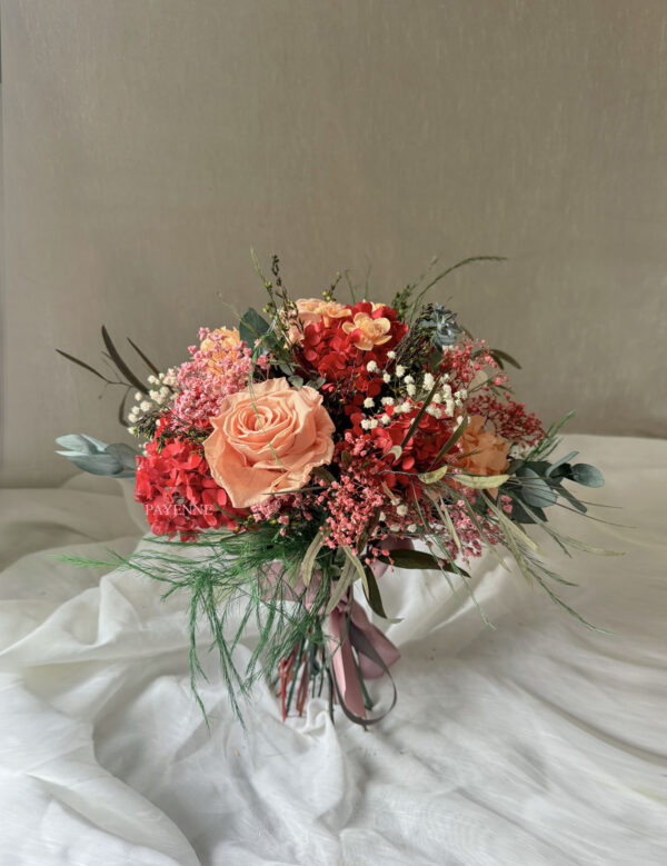 Bouquet de fleurs éternelles Siena avec des teintes corail, pêche, rouge, blanc et rose, dans un style bohème chic.